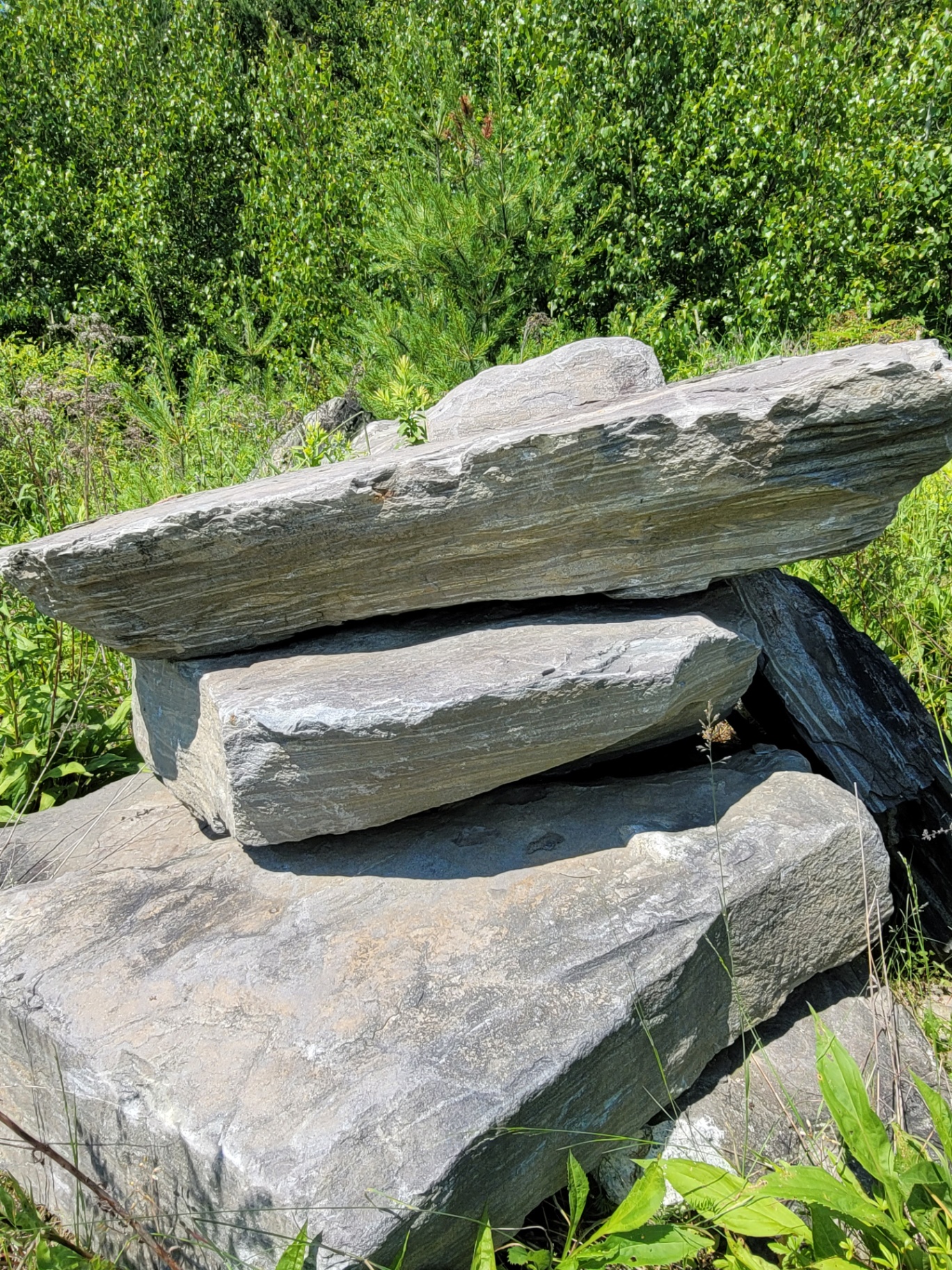 Stacked slabs of grey layered quarry stone