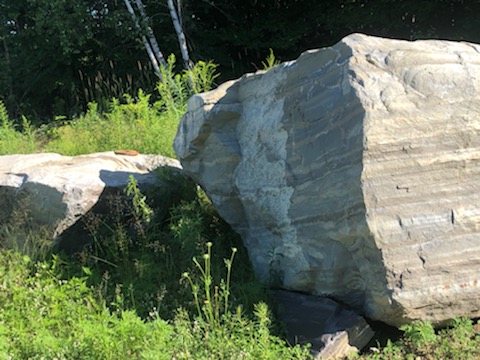 Massive freestanding quarry boulder in a clearing